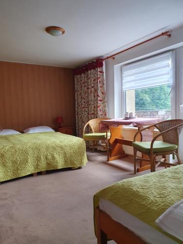 um quarto de hotel com duas camas e uma mesa e uma janela em Pokoje z widokiem na Beskid Arena em Szczyrk