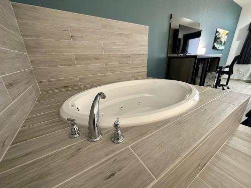 a bath tub in a bathroom with a sink at Crosby Travel Lodge and RV Park in Crosby