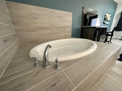 a bath tub in a bathroom with a sink at Crosby Travel Lodge and RV Park in Crosby