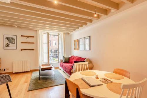 un salon avec une table et un canapé rouge dans l'établissement La Belle Place, à Honfleur