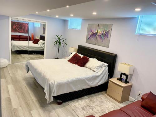 ein Schlafzimmer mit einem großen Bett und einem Spiegel in der Unterkunft Gilford Beach Apartment in Innisfil
