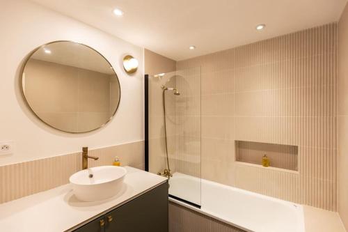 een badkamer met een wastafel en een spiegel bij La Belle Place in Honfleur