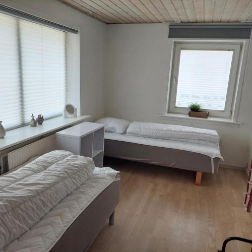 a bedroom with two beds and two windows at Villagehome North Jylland in Sindal