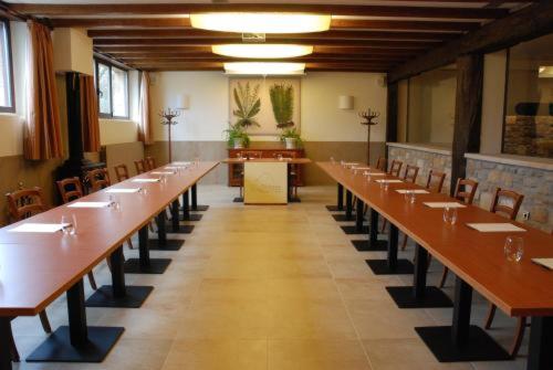 OLATZEA LANDA HOTELA في Arbizu: غرفة كبيرة مع صفوف من الطاولات والكراسي