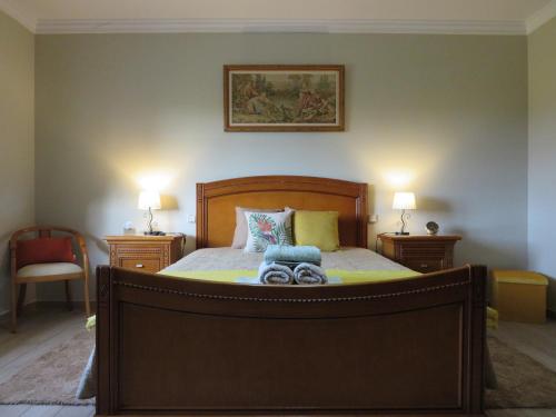 een slaapkamer met een groot bed met 2 nachtkastjes bij Casa da Fonte in Monção