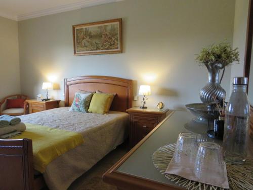 a bedroom with a bed and a table with two lamps at Casa da Fonte in Monção