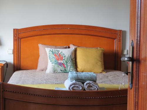 a bed with a wooden head board with donuts on it at Casa da Fonte in Monção