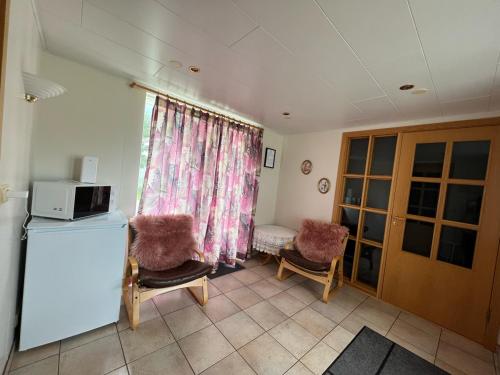 sala de estar con microondas y 2 sillas en Árstígur 7, en Seyðisfjörður