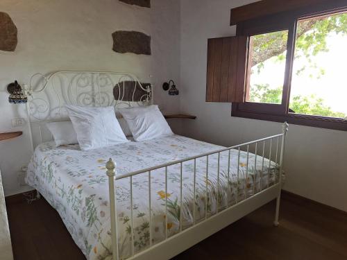 a bedroom with a white bed and a window at CASA RURAL CON PISCINA PRIVADA El ROBLE in Moya