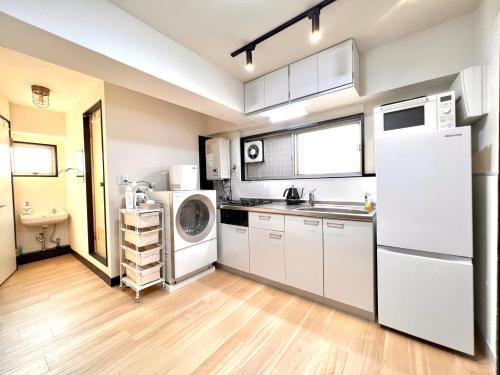 a kitchen with a white refrigerator and a sink at Ueno Retro Flower - Ueno Okachimachi in Tokyo