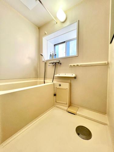 a bathroom with a tub and a sink and a window at Ueno Retro Flower - Ueno Okachimachi in Tokyo