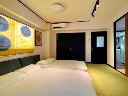 a room with two beds in a room with a door at Ueno Retro Flower - Ueno Okachimachi in Tokyo