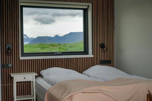 a bedroom with a window with a view of mountains at HH Gisting/Guesthouse in Hólmur