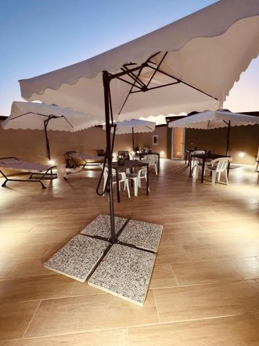 a room with tables and umbrellas on a wooden floor at Akropoli Exclusive Room in Agrigento