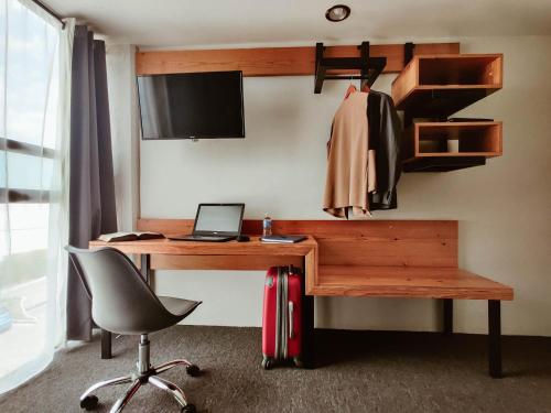 - un bureau avec un ordinateur portable et une chaise dans la chambre dans l'établissement Hotel Brisas Express, à San Cristóbal de Las Casas