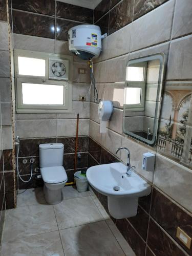 y baño con aseo y lavamanos. en Comfort suite en El Cairo