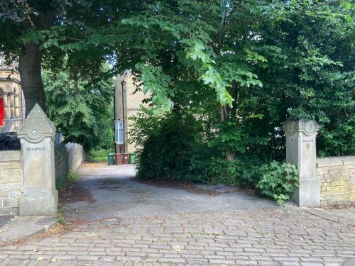 un grand arbre devant un bâtiment dans l'établissement Sedgefield, à Huddersfield