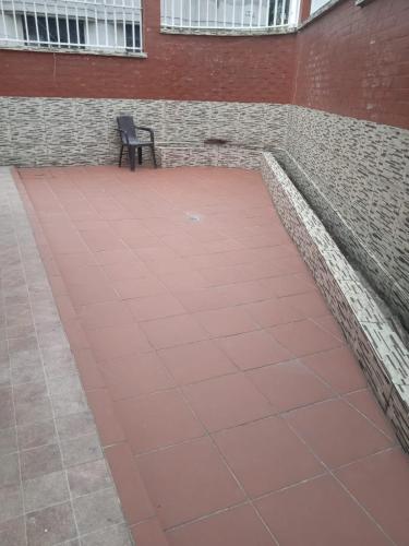 a bench sitting on a red tile floor next to a building at Departamento grande 4 dormitorios, 3 baños con garage gratuito in Quito