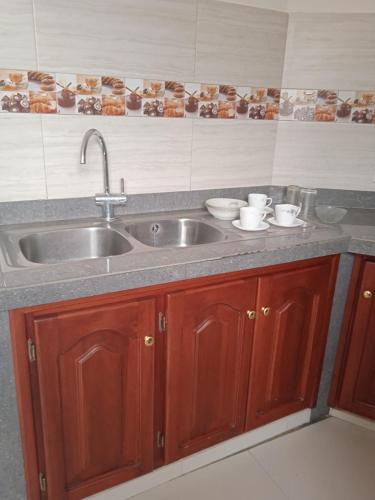 a kitchen counter with a sink and two cups at Departamento grande 4 dormitorios, 3 baños con garage gratuito in Quito