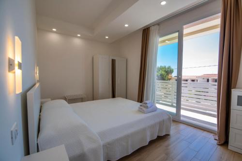 a bedroom with a white bed and a large window at Charming House Sveleo - SiciliaVacanza in Marzamemi