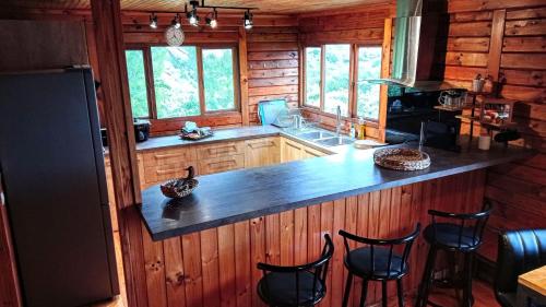 una cucina con bancone e sedie in una cabina di Chalet TanZanTan a La Plaine-des-Palmistes
