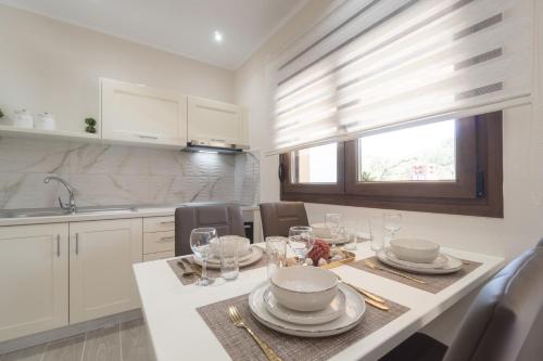 a kitchen with a table with plates and glasses on it at LUXURY VILLAS ELENI STEFI in Limenas