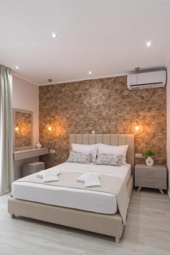 a bedroom with a large bed and a brick wall at LUXURY VILLAS ELENI STEFI in Limenas