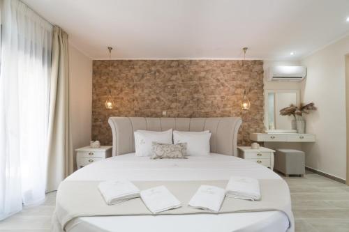 a bedroom with a large white bed with two pillows at LUXURY VILLAS ELENI STEFI in Limenas