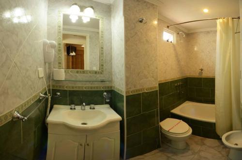 a bathroom with a sink and a toilet and a tub at Hotel Paucam in Santa Teresita