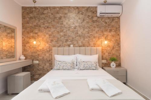 a bedroom with a bed with two towels on it at LUXURY VILLAS ELENI STEFI in Limenas