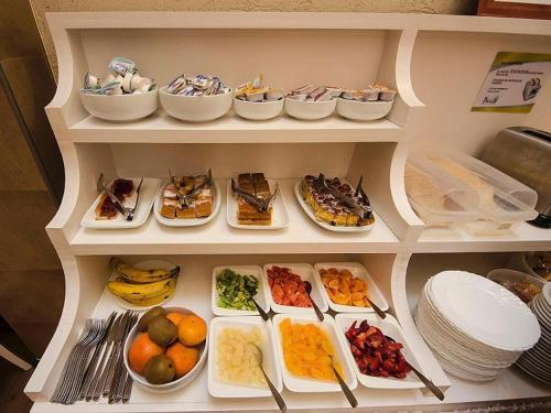 a shelf filled with appetizers and plates of food at Hotel Paucam in Santa Teresita