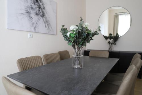 ein Esstisch mit einer Vase mit Blumen darauf in der Unterkunft Spacious Apartment, 3 min to U6 Alserstraße in Wien