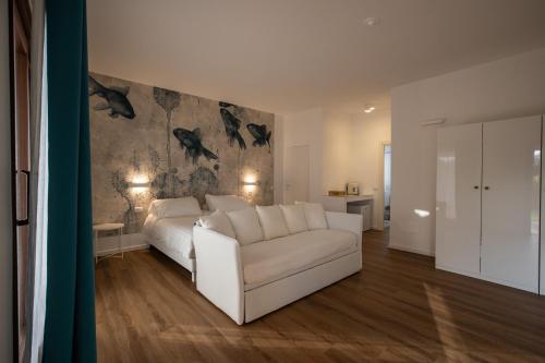 a living room with a white couch and a bedroom at Il Borgo Boutique Rooms by KasaVacanze in Porto San Paolo