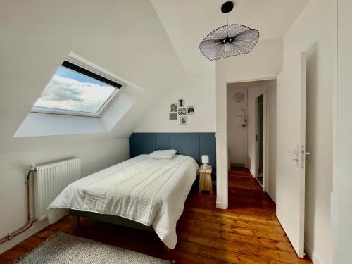 une chambre avec un grand lit avec une fenêtre dans l'établissement Maison familiale proche centre ville, à Amiens