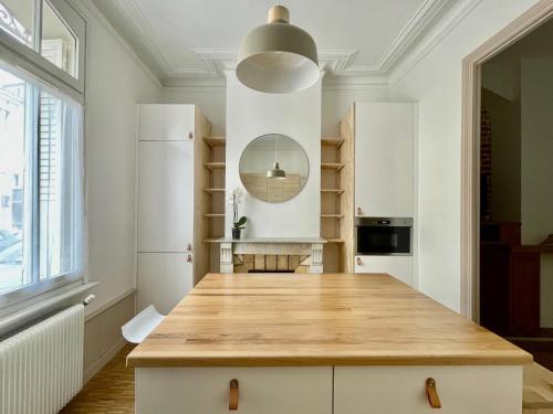 une cuisine avec des armoires blanches et un comptoir en bois dans l'établissement Maison familiale proche centre ville, à Amiens