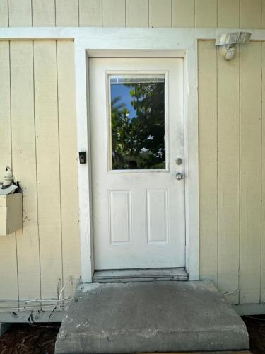 eine weiße Tür mit Fenster auf einem Haus in der Unterkunft Small Paradise in Indiantown