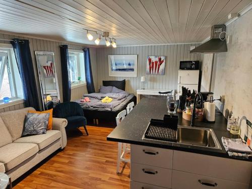 cocina y sala de estar con sofá y mesa en Casa Monami Leilighet i naturen nær Bergen, en Lonevåg