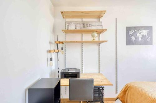 Cette chambre comprend un bureau avec un ordinateur et un lit. dans l'établissement Flat Design St Denis 4 personnes, à Saint-Denis