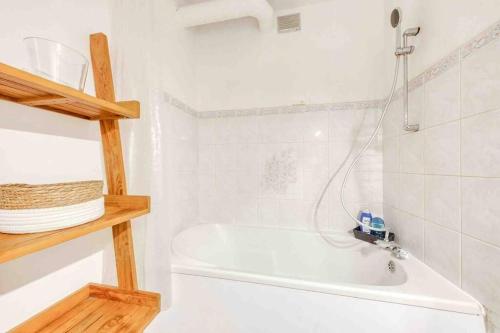 ein weißes Badezimmer mit einer Badewanne und einem Waschbecken in der Unterkunft Flat Design St Denis 4 personnes in Saint-Denis