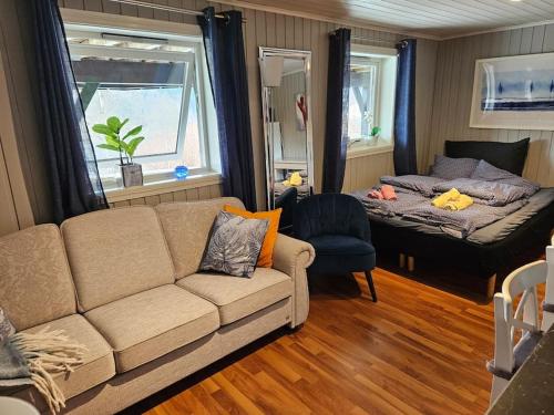 sala de estar con sofá y cama en Casa Monami Leilighet i naturen nær Bergen, en Lonevåg