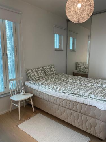 1 dormitorio con 1 cama grande y 1 silla en Casa Onni, en Helsinki