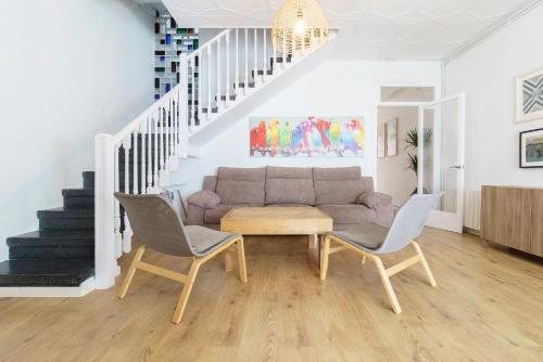 sala de estar con sofá y 2 sillas en Casa Premia en Premiá de Mar