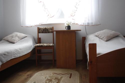 a bedroom with two beds and a chair and a window at Ugeni ,apartament in Ostrowo