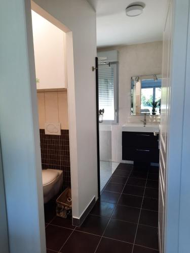 een badkamer met een toilet, een wastafel en een bad bij O BELLOC in Lapeyrouse-Fossat