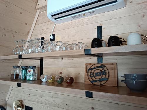 eine Küche mit Holzregalen und Gläsern darauf in der Unterkunft Stone Chalets - TERRA in Jajce