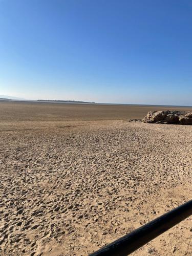 an empty beach with a fence in the foreground at Robins Nest Guest House in Great Meols