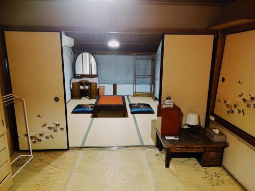 Habitación con mesa y escritorio. en Fukubatake B&B, en Yoshino