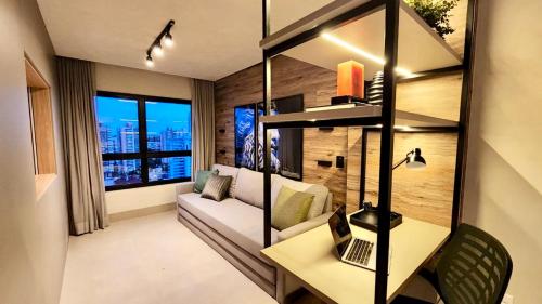 un soggiorno con divano e tavolo di Loft de Luxo c/ Home Office ao lado Shopping CG. a Campo Grande