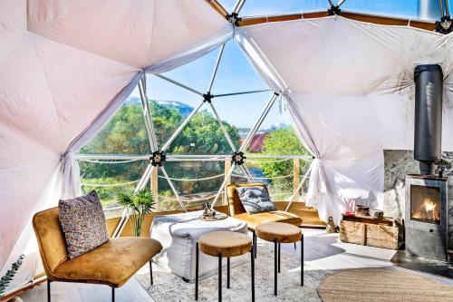 a room with a tent with chairs and a table at Storjord Farmstay Glamping in Tromsø