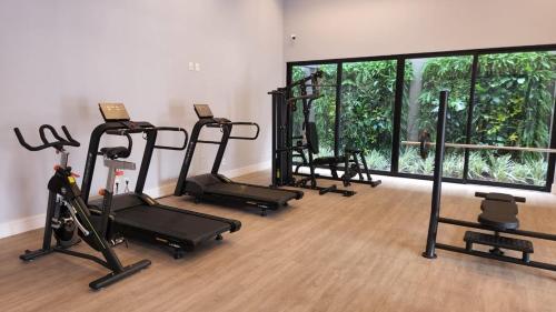 a gym with several exercise bikes and a large window at Loft de Luxo c/ Home Office ao lado Shopping CG. in Campo Grande
